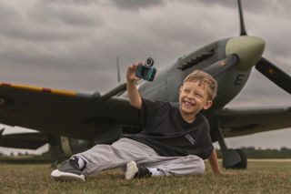 A Boy Sat Taking A Selfie In Front Of A Spitfire. © The Shuttleworth Trust. Photo Phil Chaplin